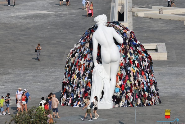 A statue of a person with a pile of clothes