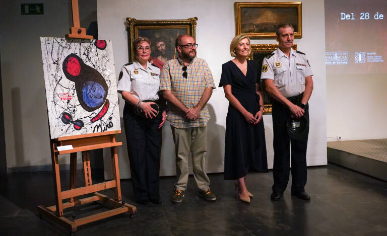 A group of people standing in front of a paintingDescription automatically generated